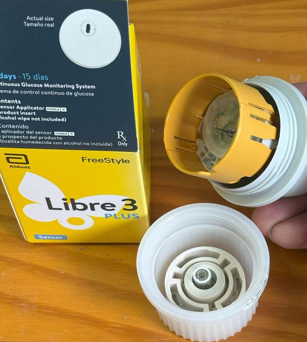 FreeStyle Libre 3 Plus Continuous Glucose Monitoring System device opened to show sensor applicator inside.