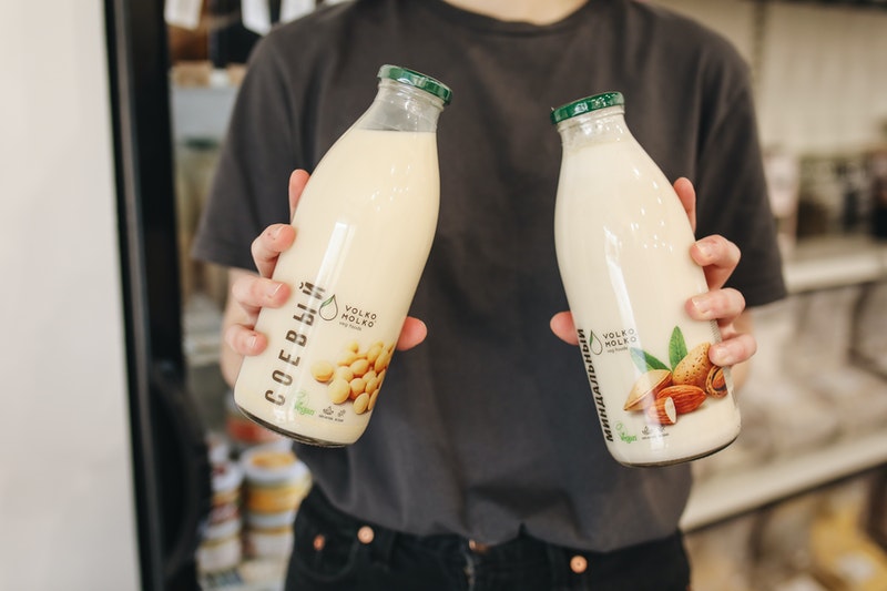 Person holding two bottles of almond milk