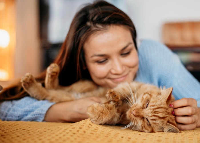 An image portraying a woman engaged in a conversation with her cat.