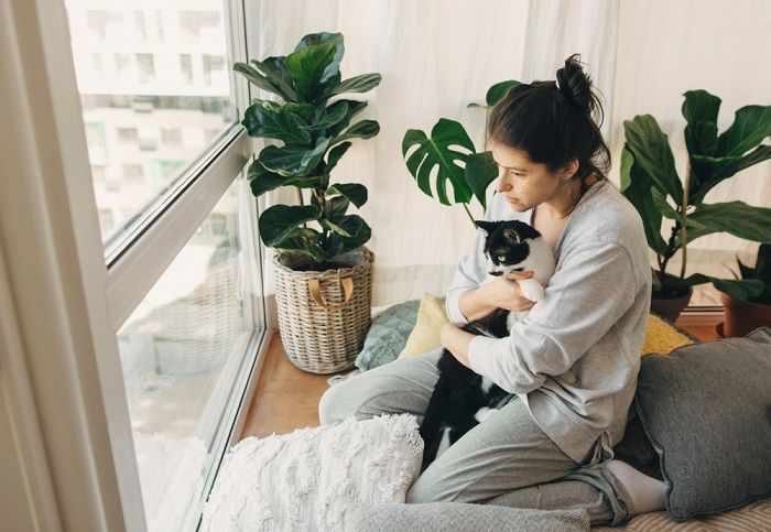 Image of a woman spending quality time with her cat, showing the special bond between them.
