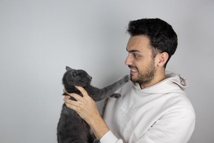 The image captures a heartwarming moment between a cat and a man.