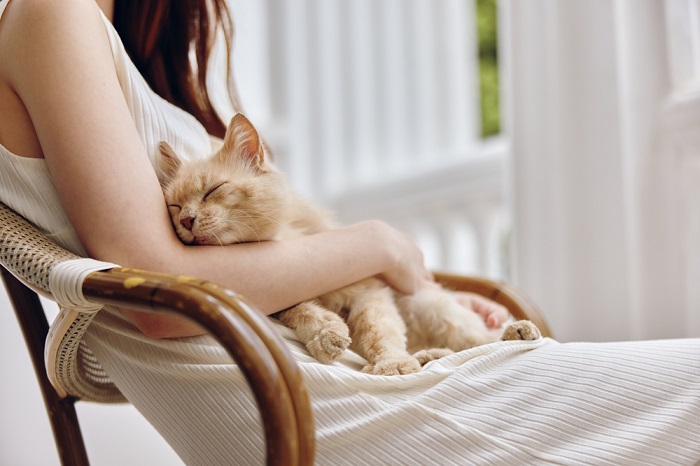 A woman enjoying a peaceful moment with her cat, a serene and heartwarming connection between human and feline.