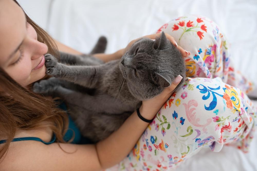 Cat putting paws on a girl's face.