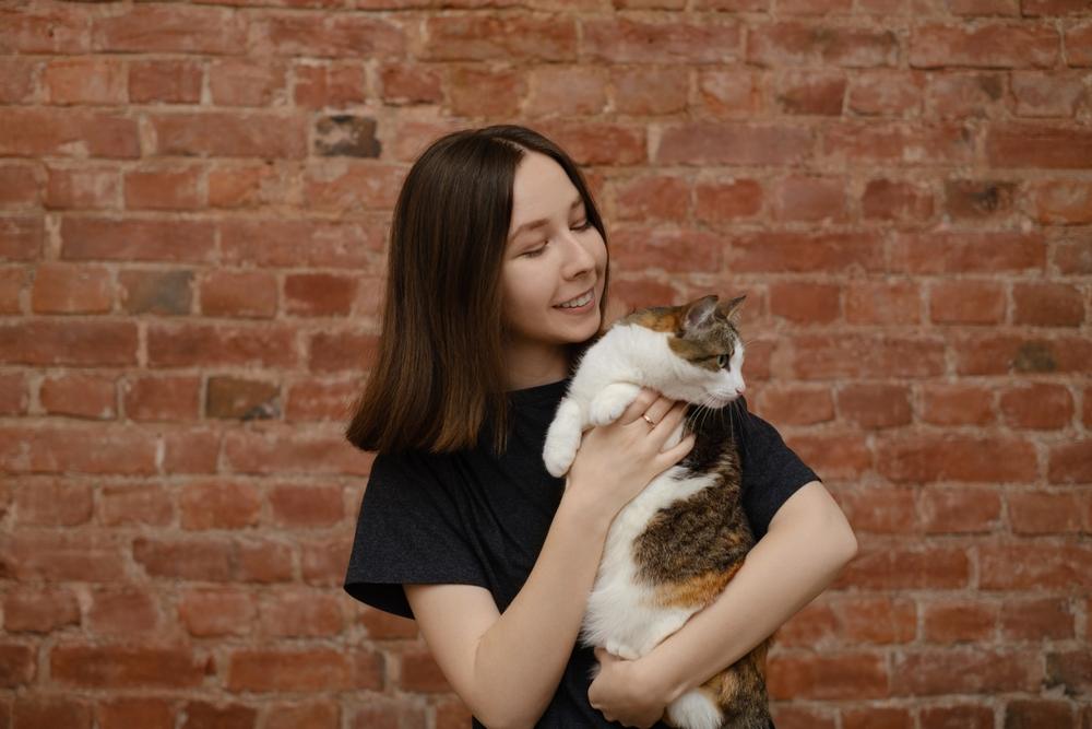 woman hold cat looks away