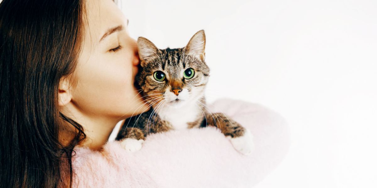 woman kisses and hugs cat