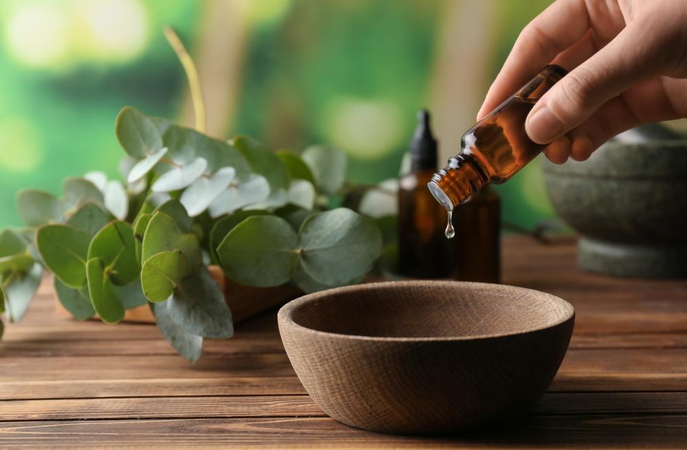 An image capturing a woman delicately pouring eucalyptus essential oil