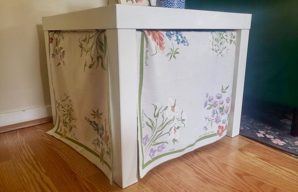 End table with fabric covering the sides to hide a cat litter box.